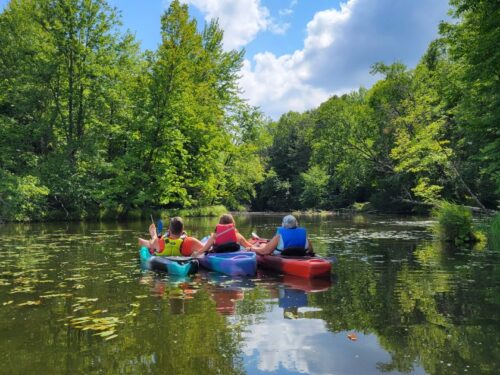 Three girls kayaking down river
