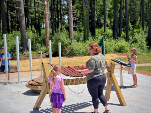 Family playing with musical playground at Erickson Park