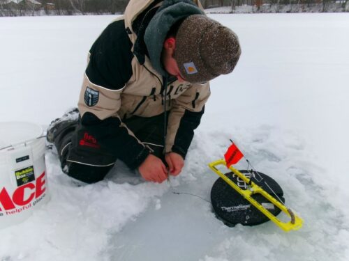 Man hooking up ice fishing rig
