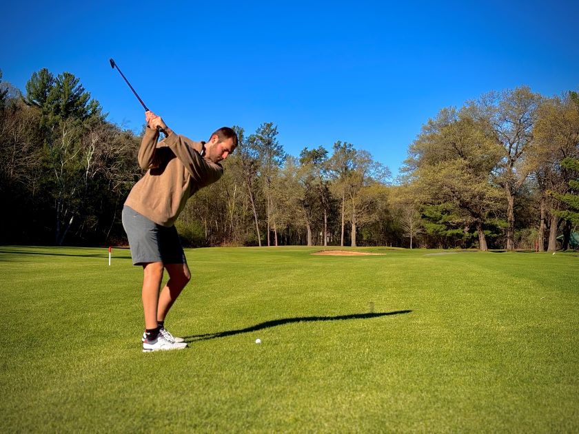 Man taking a golf swing at lake hallie golf