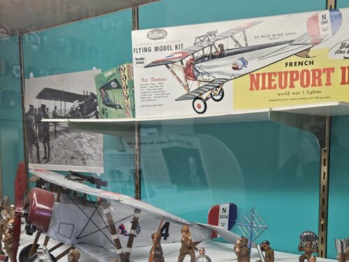 Model of an old airplace surrounded by toy plastic soldiers