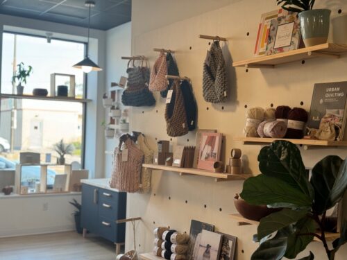 Knitted items hanging from a wall at Lagom