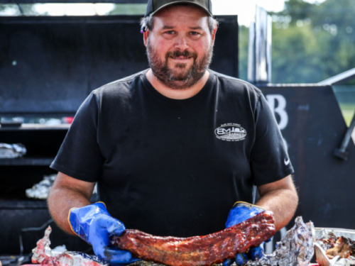 Man holding up rack of ribs at the competition 
